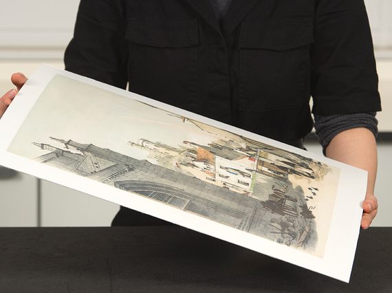 A curator holding an unframed artwork